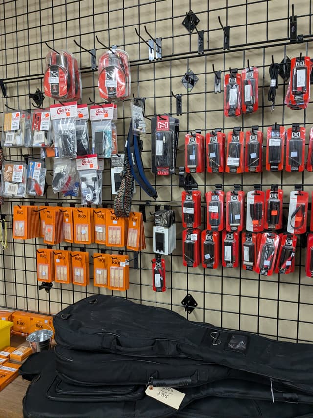 Music accessories including instrument reeds, Neotech guitar straps, cables, and gig bags
