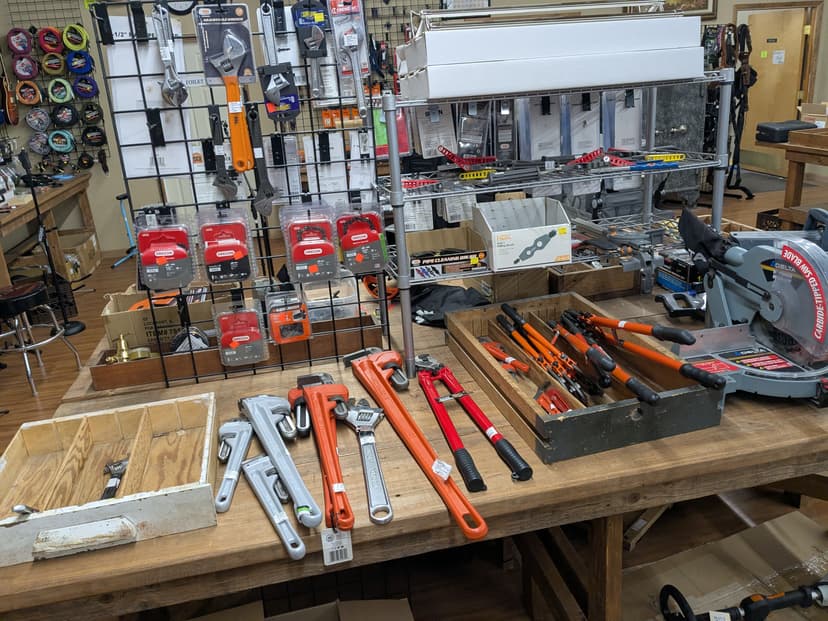 Tools including pipe wrenches, Oregon chainsaw chains, bolt cutters, and a Delta miter saw