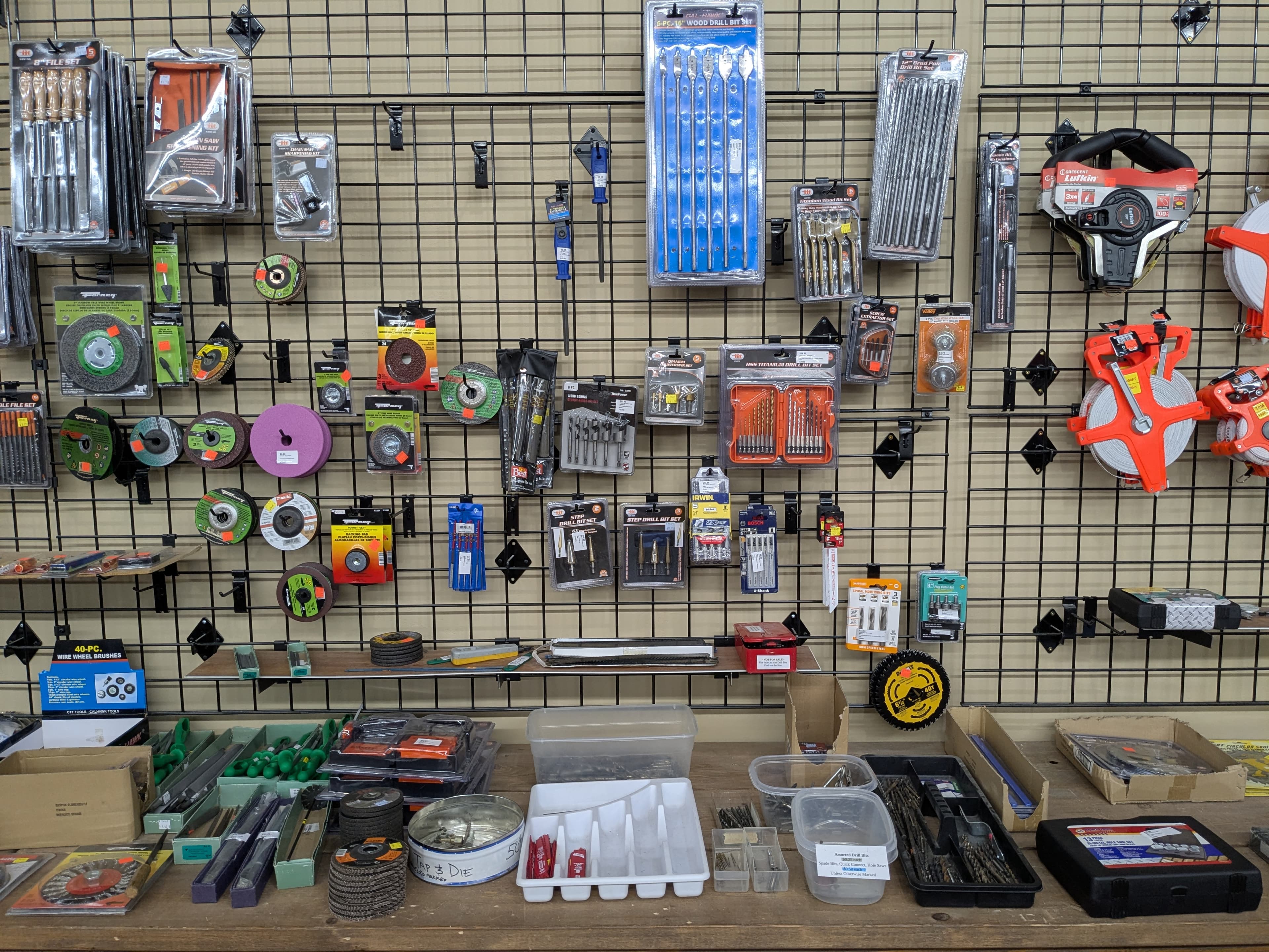 Drill bits, grinding wheels, wire brushes, measuring tapes, and tap and die sets on display